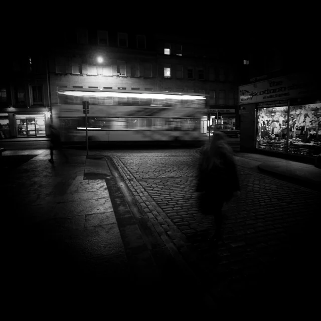 Un tramway photographié de nuit dans une rue sombre.